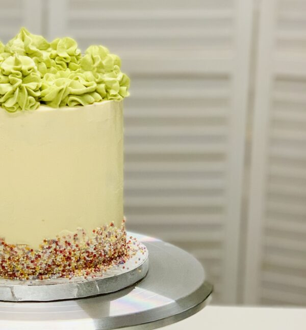 close up of sprinkles and swirls on a buttercream cake
