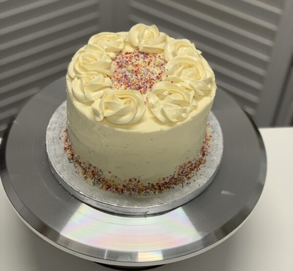 Buttercream cake with sprinkles and iced rose swirls