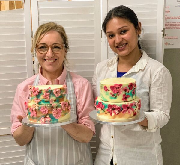 Two happy students with their wedding cakes